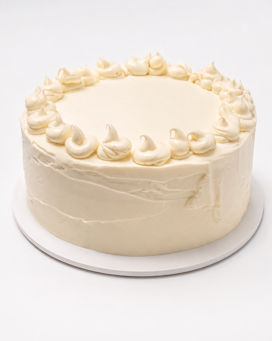 Amaretto Cake — white frosted layer cake topped with piped frosting dollops